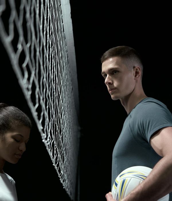 Professional athlete performing a strength exercise in a dark studio.